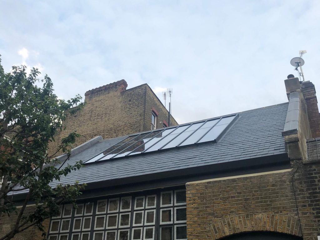 Slate roof installation with large skylight windows on residential property in London by K Class Construction