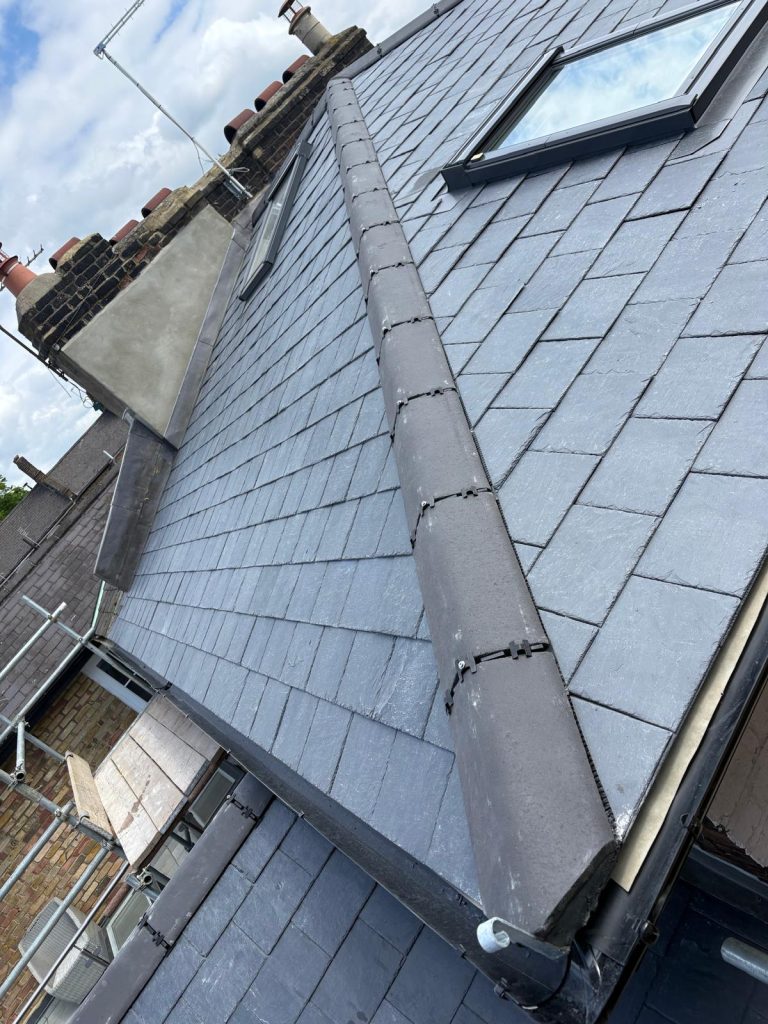 Completed slate roof installation by roofers in North London with roof windows and leadwork